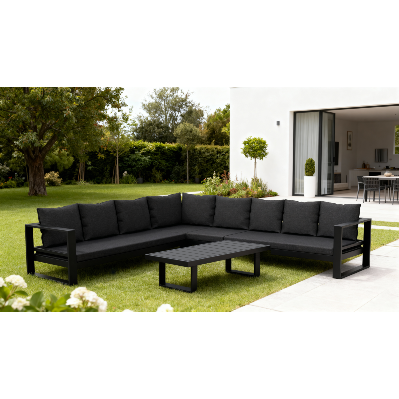 Garden seating area featuring a dark sofa with red patterned cushions, a glass vase of flowers on a table, and a parasol.