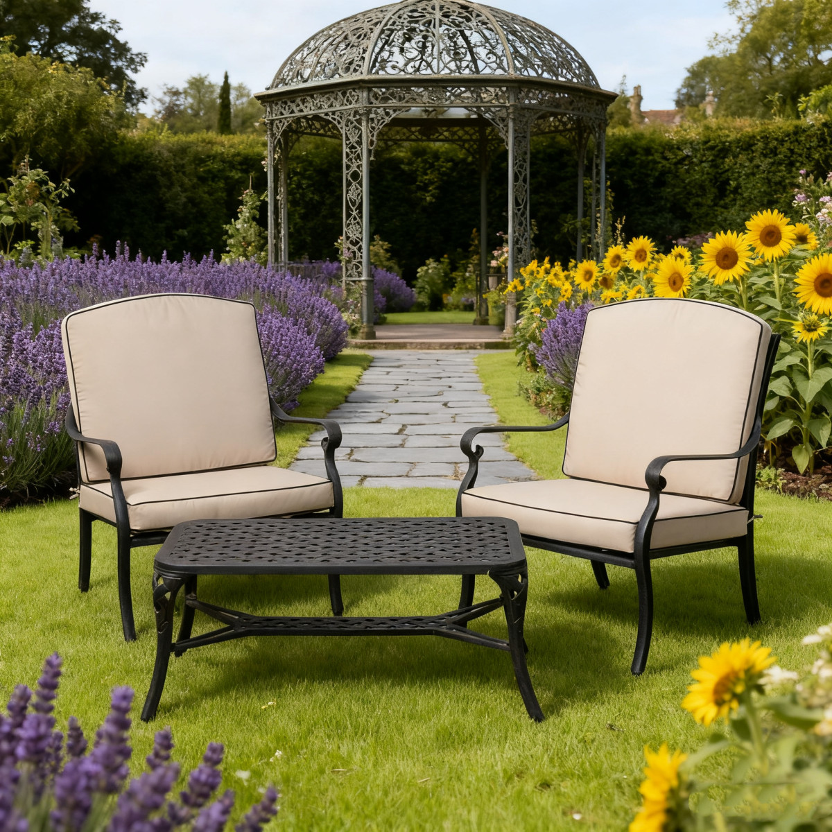 Two bright yellow outdoor chairs facing a black table with fruit, set in a lush garden with colourful flowers.