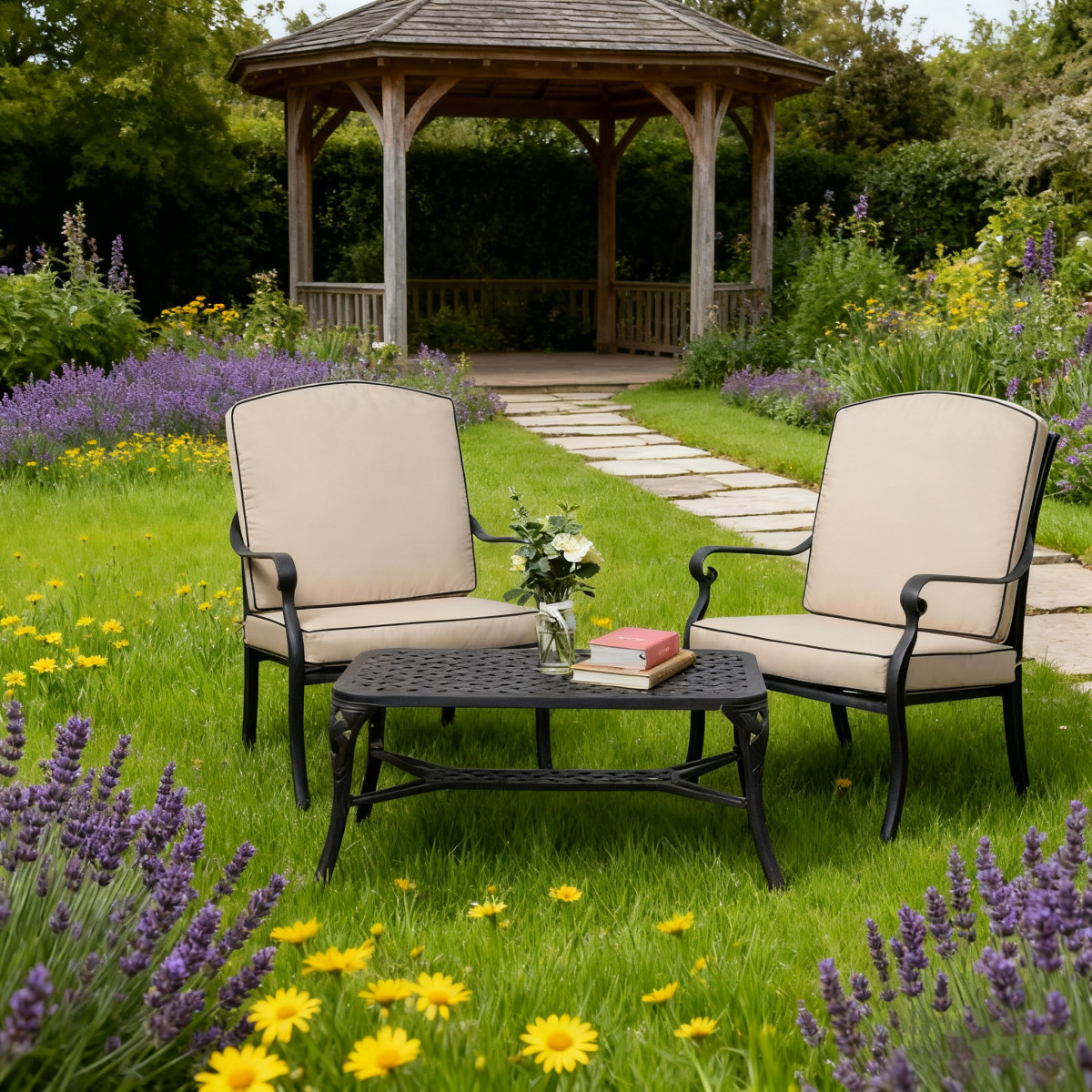Two bright yellow armchairs are placed opposite a round black metal table on gravel, surrounded by greenery.