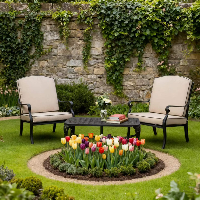 Two bright yellow outdoor chairs facing a black table with fruit, set in a lush garden with colourful flowers.