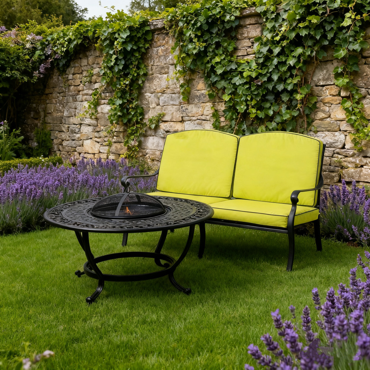 Two bright yellow armchairs are placed opposite a round black metal table on gravel, surrounded by greenery.